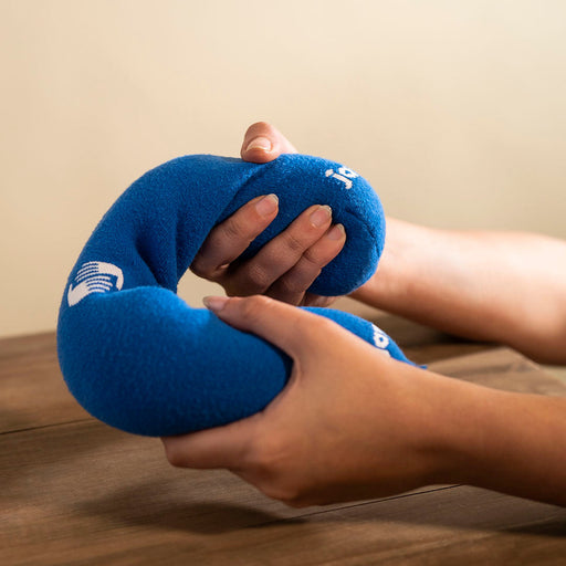Blue Hand Warming Grippie being squeezed by two hands.  Rice sock. rice sock heating pad. heated rice sock. hand warmers reusablehand warmers. microwaveable hand warmers. hand pain treatment. how to relieve sore hands from work. how to reduce hand pain.