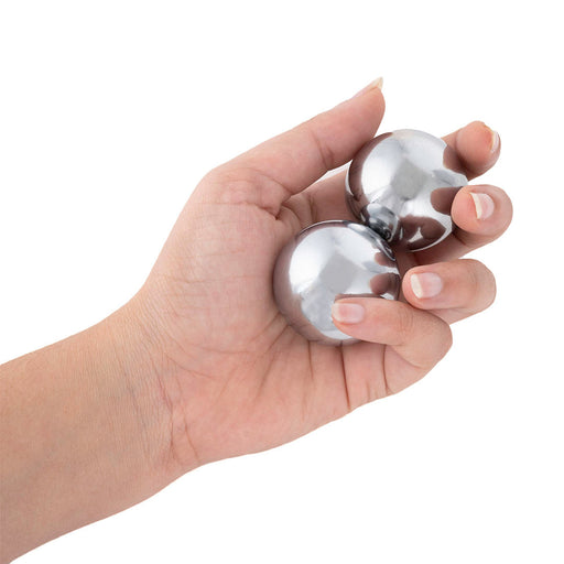 Medium Baoding balls with chimes in a woman's hand.  These chrome Baoding balls are great for arthritic hands or carpal tunnel.  Hand care products.